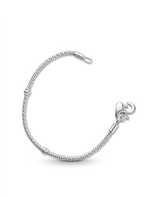 a close up of a silver bracelet on a white background
