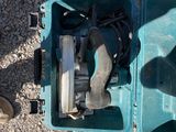 une mallette bleue posée par terre, contenant un outil
