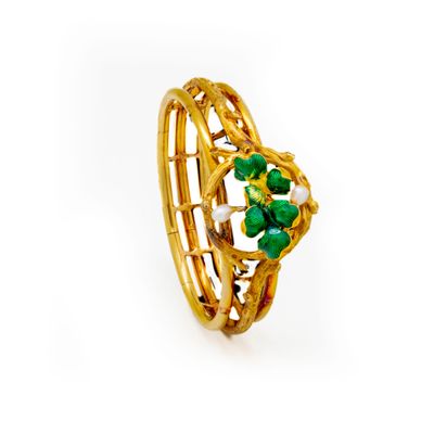 a close up of a gold ring with green stones