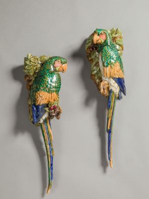 two green and yellow parrots sitting on top of each other