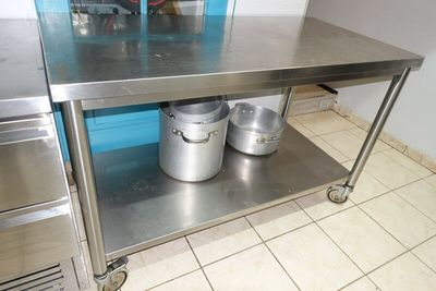 SUR DESIGNATION : Un plan de travail inox sur roulettes *** …