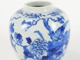un vase bleu et blanc posé sur une surface blanche