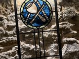 a stained glass window in the middle of a stone wall