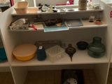 une étagère blanche sur laquelle sont posés de nombreux objets, dans une pièce
