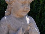 a statue of a little boy holding a bird in his hands