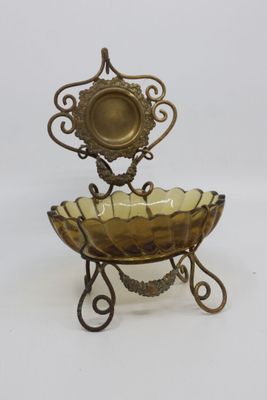 a metal stand with a glass bowl on top of it