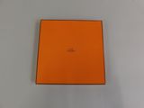 an orange box on a white surface with a small logo on it