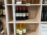 des bouteilles de vin sur une étagère dans un magasin, avec leurs étiquettes de prix