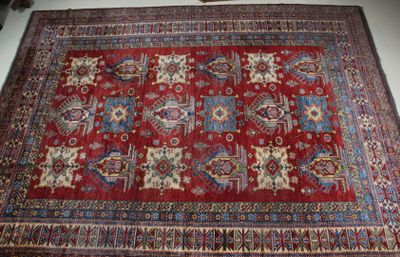 un tapis rouge à motifs posé sur un sol blanc