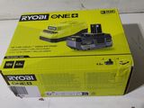 La boîte de la batterie Ryob One 2 est ouverte sur la table.
