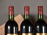 three bottles of red wine are lined up on a table