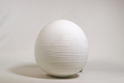 un vase blanc posé sur une surface blanche