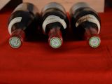 three bottles of wine sitting on a red table cloth