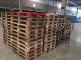 several pallets of wood stacked up in a warehouse area