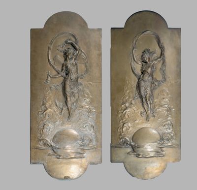 deux sculptures métalliques représentant des anges, fixées à un mur et entourées d'eau et de nuages