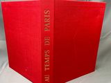 a red book sitting on top of a white cloth covered table