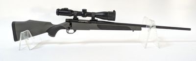 un fusil équipé d'une lunette de visée, posé sur un support transparent
