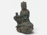 statue of a woman sitting on a rock holding a cat