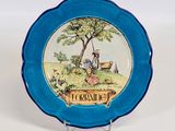 une assiette bleue sur laquelle est représenté un homme et une femme