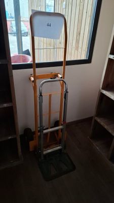 a hand truck that is sitting in front of a window