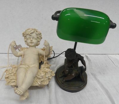 une petite statue représentant un bébé assis sur une table, à côté d'une lampe