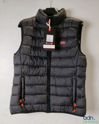 Le gilet est noir et porte une étiquette rouge.