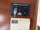 a clock on the door of a hotel room with a key in it