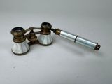a pair of antique brass and glass binoculars on a white surface