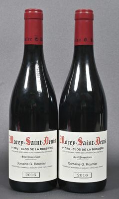two bottles of red wine sitting next to each other on a table