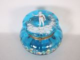 une boîte en verre bleue sur laquelle est posée une figurine