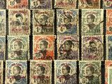 a group of stamps of different sizes and colors on a black surface