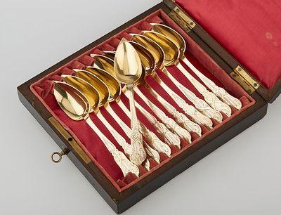 six silver spoons in a wooden box with a red lining