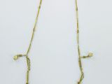 un collier en or orné de pièces de monnaie sur fond blanc