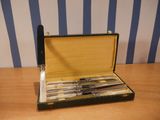 an image of a set of knives in a case on a table