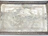 an ornate silver tray with handles and handles on a white surface