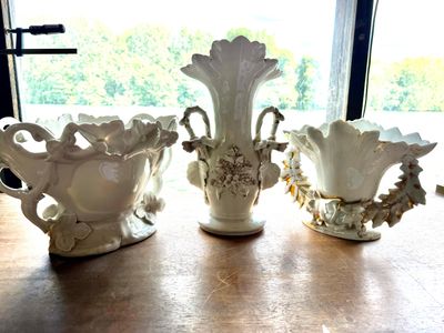 trois vases posés sur une table, avec une fenêtre en arrière-plan