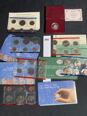 some coins are sitting on top of a table next to a book