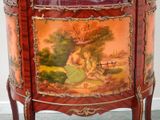 a small cabinet with a painting on it