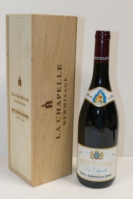 une bouteille de vin posée à côté d'une caisse en bois