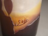 a tall glass with a brown and white design on it
