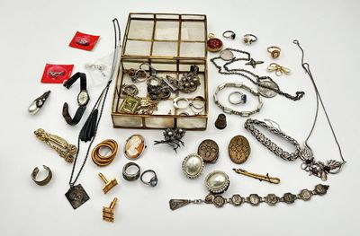 une boîte remplie de bijoux variés posée sur une surface blanche