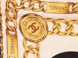 chanel scarf with gold chains and medallions on a white background