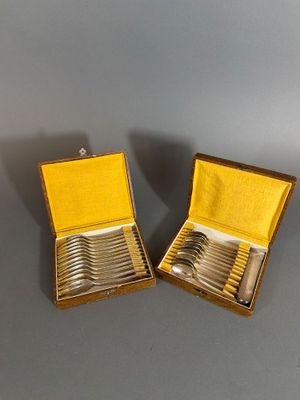pair of silver plated spoons in a box on a table