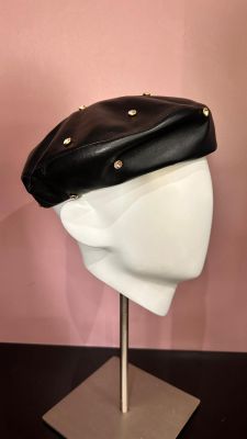 une tête de mannequin blanche coiffée d'un chapeau noir