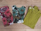 three women ' s clothing laying on a wooden floor next to each other