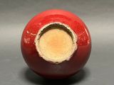 a red ball with a hole in it on a gray surface