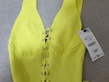 a yellow cropped top with laces on the front