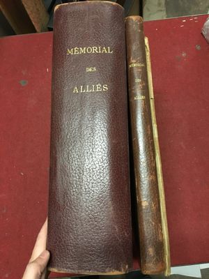 un vieux livre à la couverture en cuir posé sur une table rouge