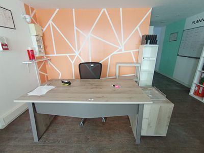 un bureau avec une chaise et une étagère dans le coin
