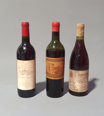 trois bouteilles de vin sont alignées sur une surface grise